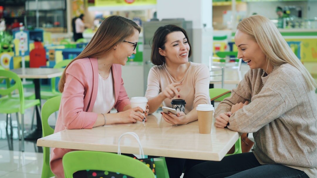 Group of senior friends laughing together over coffee at a table